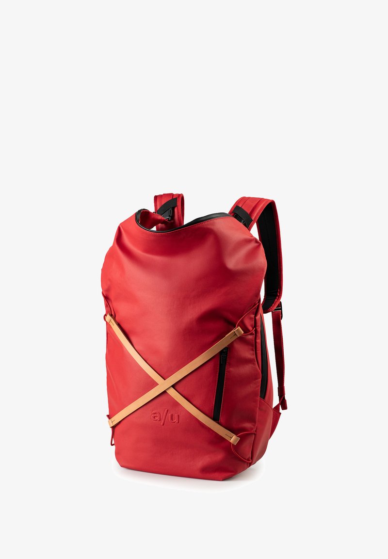 Rode waterdichte rugzak met een ronde vorm, zwarte rits en contrasterende beige banden in een X-patroon aan de voorkant.