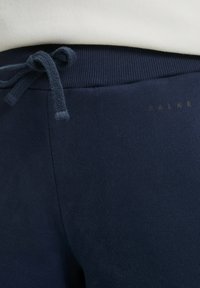 Marineblauwe sweatpants met een gestructureerde tailleband en bijpassend trekkoord, voorzien van een subtiel logo in goud. Zachte stof met een gladde afwerking.