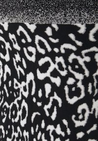 Schwarzer Stoff mit einem weißen Leopardenmuster. Die Textur erscheint weich, mit einem kontrastierenden, glitzernden oberen Abschnitt in einem ähnlichen Farbschema.