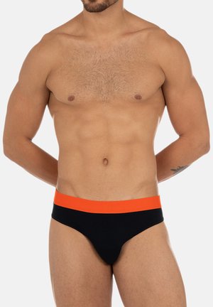 Schwarze Schwimmslips für Männer mit einem elastischen, orangefarbenen Bund, die eine glatte Textur und ein eng anliegendes, tief sitzendes Design aufweisen.