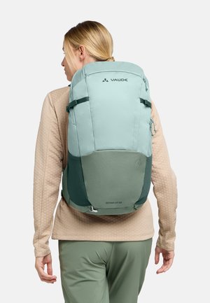 Zaino VAUDE Skomer Zip 22 verde chiaro con superficie texture, doppie cinghie di compressione e un ampio scomparto principale.