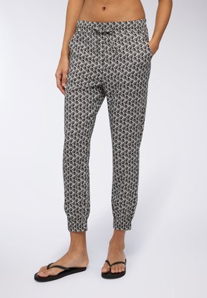 Pantaloni jogger a strisce in bianco e nero con vita elasticizzata, tasche laterali e polsini a gamba stretto, realizzati in tessuto leggero.