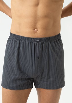 Dark gray boxers made from textured fabric, featuring an elastic waistband and a button fly. The design includes a subtle pattern throughout.