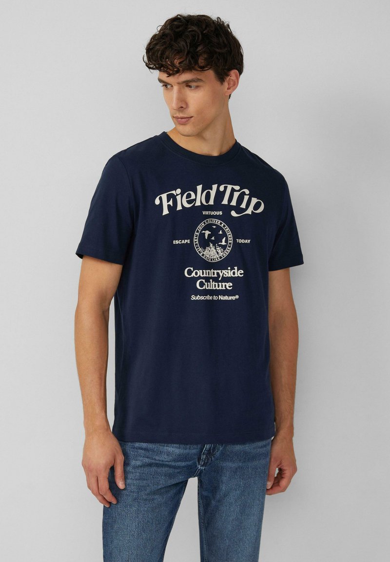 Marineblauwe katoenen t-shirt met een witte grafische print die tekst en een cirkelontwerp bevat. Korte mouwen en een ronde hals.