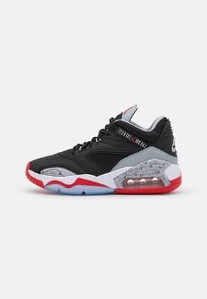 Zapatilla deportiva de caña alta en negro, gris, rojo y blanco con amortiguación visible de aire y detalles moteados en la mediasuela y acentos superiores.