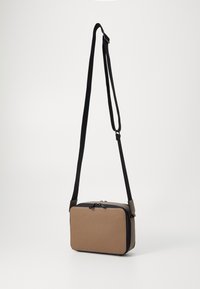 Prostokątna torba na ramię z teksturowanego brązowego materiału z czarnym zamkiem i paskiem. Charakteryzuje się gładkim wykończeniem i kontrastującymi przeszyciami.