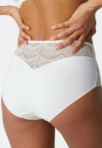 Weiße hochgeschnittene Unterhose mit einem Spitzenpanel oben und einem gewellten Muster. Glatter Stoff und ein V-förmiges Detail auf der Rückseite.