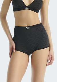 Czarne majtki z wysokim stanem, z teksturowanym wzorem, elastycznym pasem i białym logo z przodu. Miękki materiał.