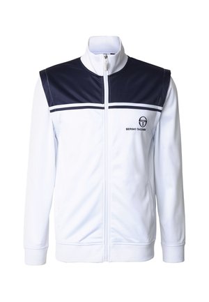 Witte trainingsjas met een marineblauw paneel op de schouders, rits aan de voorkant, geribde kraag en manchetten, en een logo op de linkerborst.