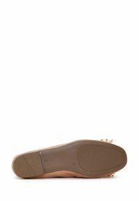 Zapato plano nude con suela de goma lisa; acentos decorativos de flores doradas en el talón; tamaño 36 indicado en la suela.