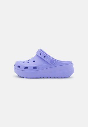 Liliowy chodak z wentylowanymi otworami, regulowanym paskiem na górze i grubą, teksturowaną podeszwą zapewniającą amortyzację.