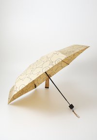 Parapluie de couleur crème avec un motif floral noir, de forme courbée, poignée noire et sangle ajustable. Design léger pour la portabilité.