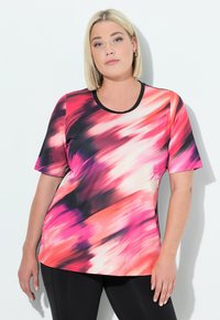 Top de manga corta con un vibrante patrón abstracto en tonos de rosa, negro y blanco. Fabricado con una tela suave, presenta un escote redondeado y un ribete en contraste.