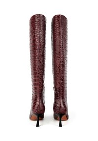 Ginčiais iki kelių, bordo spalvos dirbtinės odos batai su krokodilo tekstūra, smailiu priekiu ir plonu stiletto kulnu. Glotnus paviršius su elegantišku dizainu.