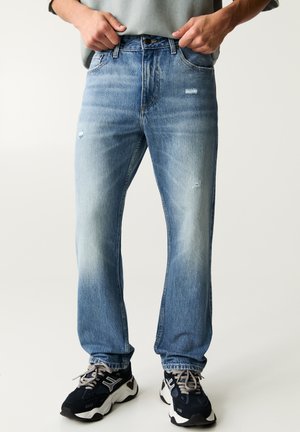 Blugi din denim bleu deschis cu croi drept, detalii uzate și decolorare subtilă. Au cinci buzunare și închidere cu nasture.