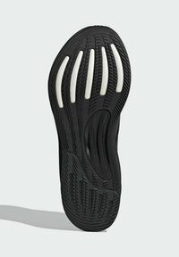Suela de zapatilla negra con textura en el dibujo, que presenta acentos de entresuela blanca y ranuras alargadas para un mejor agarre. Forma redondeada para mayor comodidad.