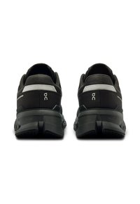 Scarpe atletiche nere con un design elegante, tomaia in tessuto, dettagli riflettenti, suola ammortizzata e suola in gomma testurizzata per una presa ottimale.