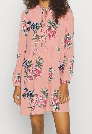 Roze bloemenjurk met lange mouwen, trekkoord-halslijn en geplooide taille. Kenmerkt zich door blauwe, rode en groene bloemenpatronen. Zachte stoftextuur.