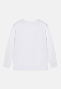 Vit långärmad t-shirt i bomull. Har en rund halsringning och rak nederkant utan synliga mönster eller dekorationer.