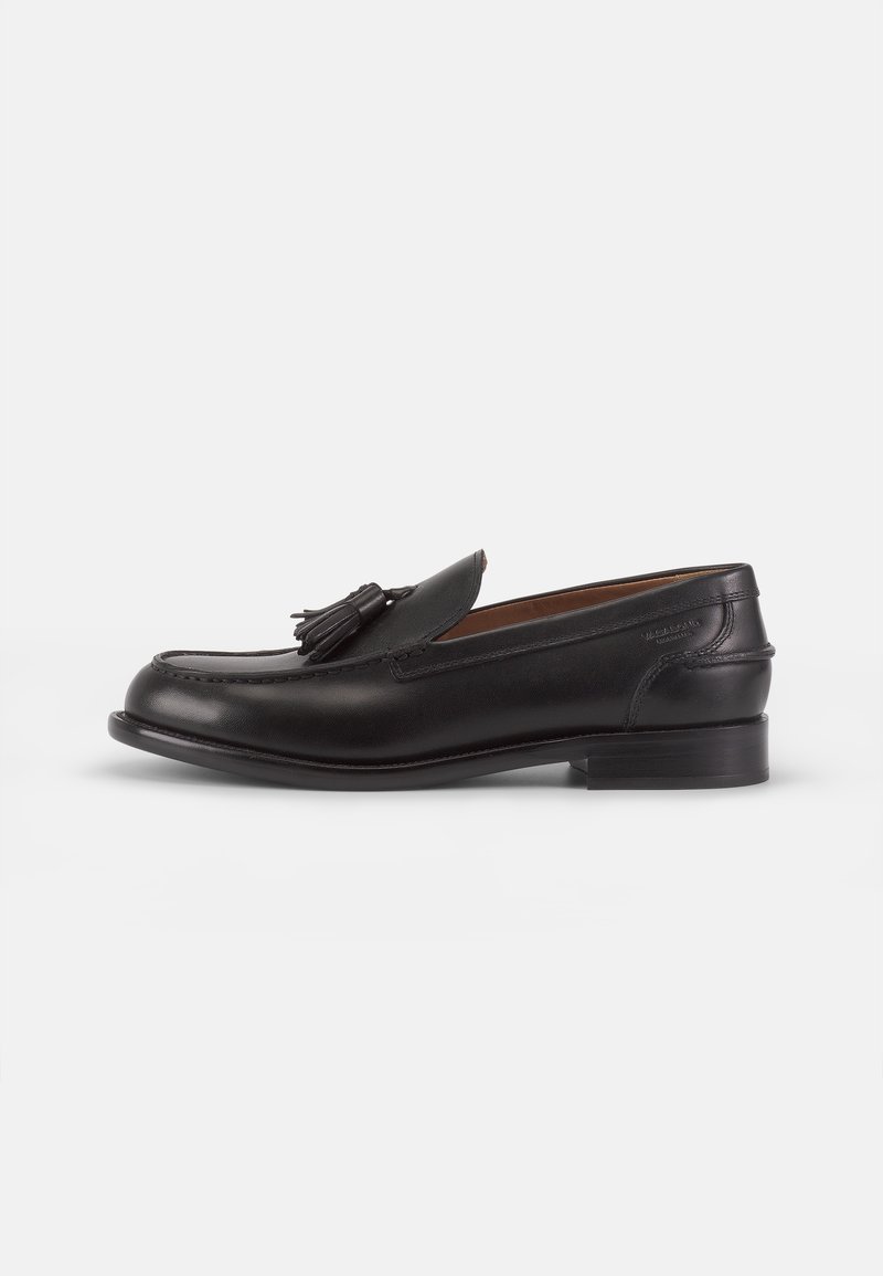Svarta lädersneakers med rund tå, prydda med en dekorativ tofs på framsidan och en låg klack. Slät yta med subtila sömnadsdetaljer.