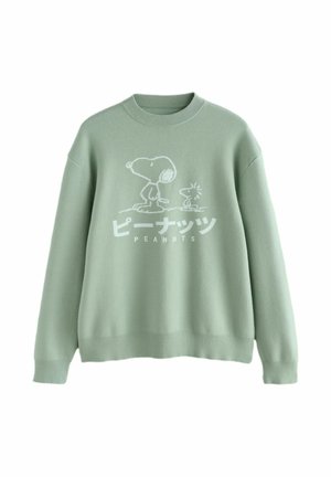 Gaiši zaļš kreklveida džemperis ar Snoopy un Woodstock zīmējumiem un japāņu tekstu virs vārda "PEANUTS" priekšpusē.