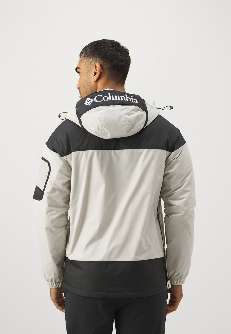 Męska kurtka Columbia w odcieniach szaro-czarnych, z regulowanym kapturem i elastycznymi mankietami. Zawiera logo na plecach.