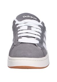 Szare trampki Adidas z białymi sznurówkami, białymi paskami po bokach i gumową podeszwą, widok z przodu.