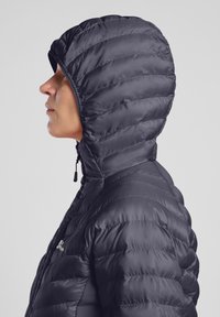 Giacca nera imbottita con colletto alto e cappuccio, con un design trapuntato e chiusura con cerniera. Il materiale sembra liscio e lucido.