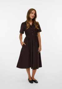 Robe marron à manches courtes, avec un col boutonné, silhouette en A, taille froncée et poches latérales. Texture de tissu lisse, design simple.