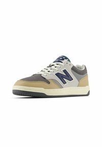 New Balance sneakers met een combinatie van beige, grijs en marineblauw suède en leer. Vetersluiting met rubberen buitenzool.