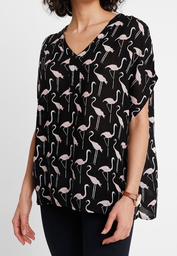 Schwarze Bluse mit V-Ausschnitt und lockerer Passform, dekoriert mit einem Muster aus rosa Flamingos und blauen Akzenten, aus leichtem Stoff gefertigt.