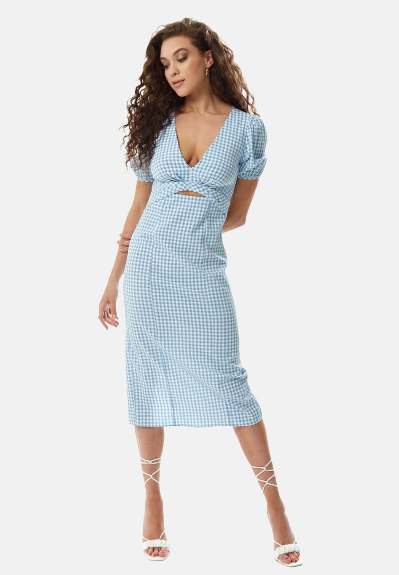 Blue and white gingham dress with a cut-out detail, short puff sleeves, and a floor-length skirt. Pairing with white strappy high heels.