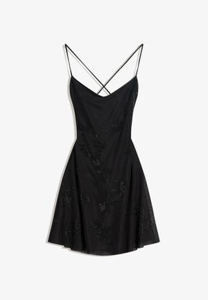 Black dress with a V-neck, thin adjustable straps, and a flared silhouette. Features floral sequin embellishments for added detail.