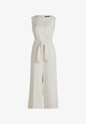 Salopette senza maniche di colore crema con design a gamba larga, cintura in tessuto in vita, leggero lucido e chiusura discreta con zip sul retro.