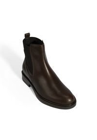 Bruine leren Chelsea-boot met elastische zijpanelen, puntige neus en een gestructureerde rubberen zool. Minimalistisch ontwerp met een aantrekband aan de hiel.