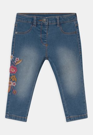 Denim capri-broek in lichtblauw met een verwassen finish. Heeft bloemrijke borduursels in roze, oranje en geel op het linkerbeen.