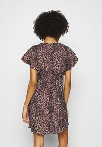 Vestido rosa con estampado de leopardo de manga corta que presenta mangas con volantes, una cintura ceñida y una falda acampanada, hecho de una tela ligera.