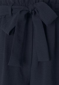 Navy blue trousers with a relaxed fit, featuring a gathered waistband, tied belt detail, and soft texture.