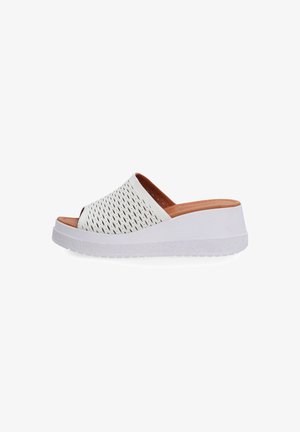 White slip-on sandals with a perforated upper design, a beige inner lining, and a textured white wedge sole.