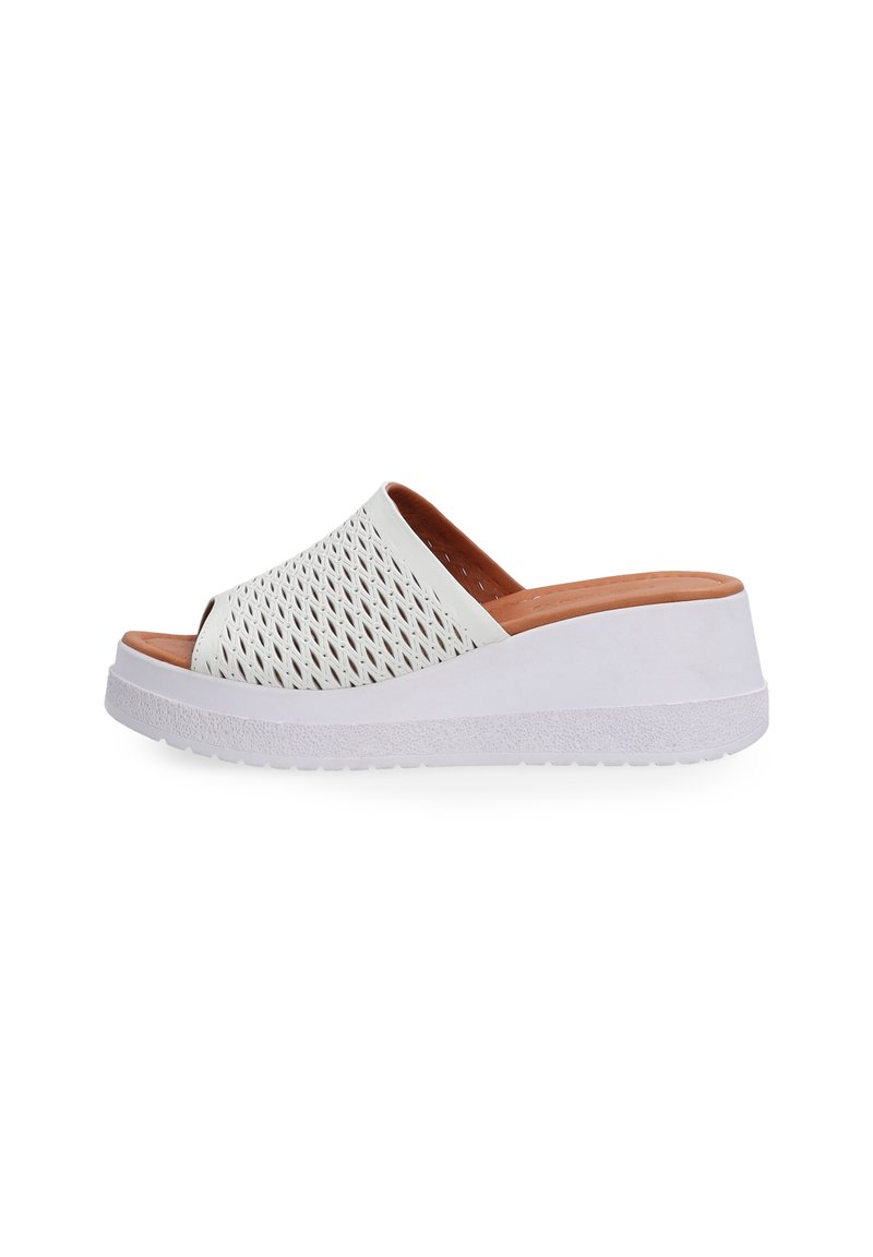 Hvide slip-on sandaler med et perforeret overdelsdesign, en beige indvendig foring og en tekstureret hvid kile-sål.