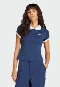 Tamno plavi polo majica kratkih rukava s bijelim ovratnikom, Adidas logom na prsima, izrađena od mekanog materijala, s prilagođenim dizajnom i čistim linijama.