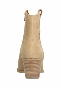 Beige suede ankle boots with a stacked wooden heel, featuring a smooth texture, rounded toe, and a pull tab at the back.