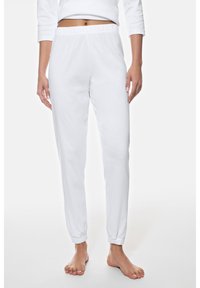 Pantalones deportivos blancos de algodón con cintura elástica y puños elásticos, con una textura suave y un diseño de pierna cónica.