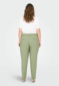 Kergelt lange, kõrge vöökohaga püksid helesinisest kangast, elastse vöökohtaga, kahe tagatasku ja kitsenevate jalgadega.