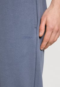 HUGO DAYOTE - Pantalones deportivos - open blue