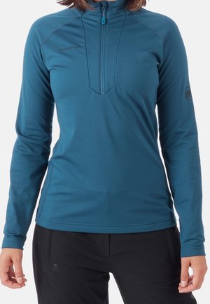 Pull-over teal à manches longues avec un col zippé demi-haut, fabriqué en tissu lisse et extensible ; présente un logo subtil et des détails de couture contrastants.