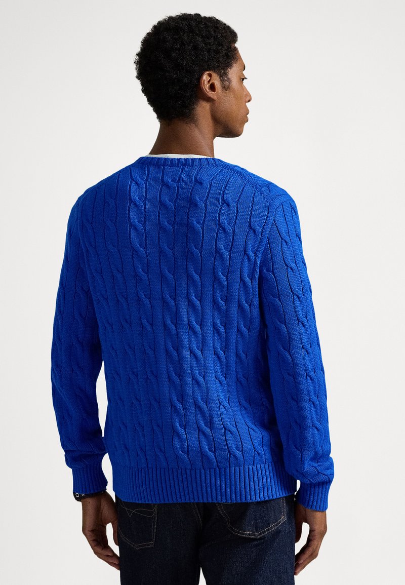 Pull en tricot à torsades bleu avec manches longues, encolure ronde et ourlet côtelé. Présente un motif texturé et une couleur unie sur l'ensemble.