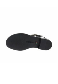 Semelle de chaussure noire avec un design de grip texturé, présentant un talon légèrement surélevé, un logo en relief et un petit détail du drapeau italien.