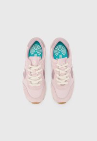 Lys rosa sneakers med en blanding av glatte og semskede teksturer, med beige snørebånd, en teal såle og en gummiyttersåle.