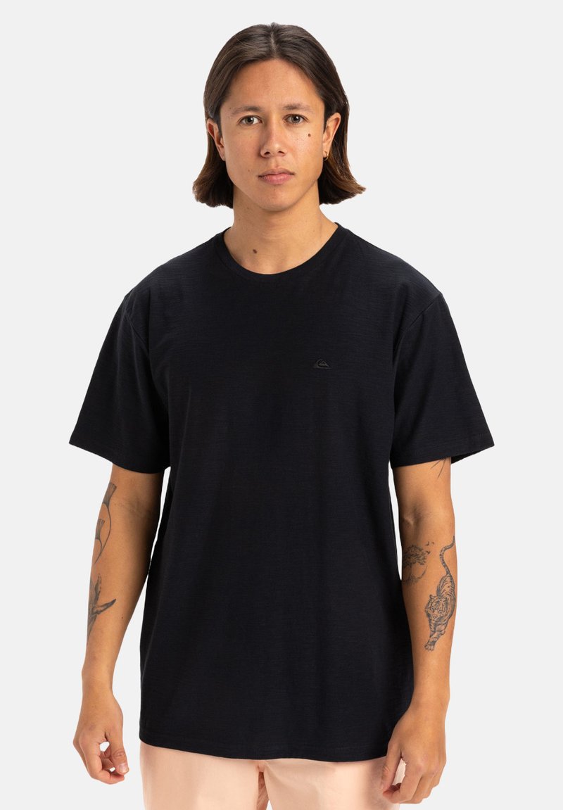 T-shirt in cotone nero con maniche corte, collo rotondo e un piccolo logo sul petto. Tessuto liscio con una vestibilità rilassata.